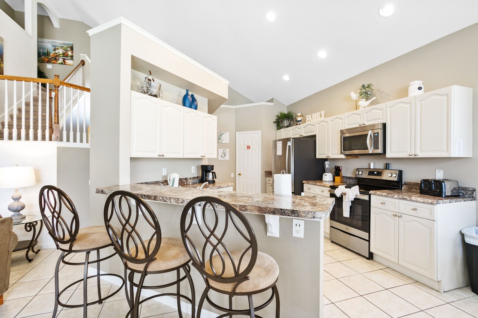 White kitchen with a breakfast island and stainless steel appliances