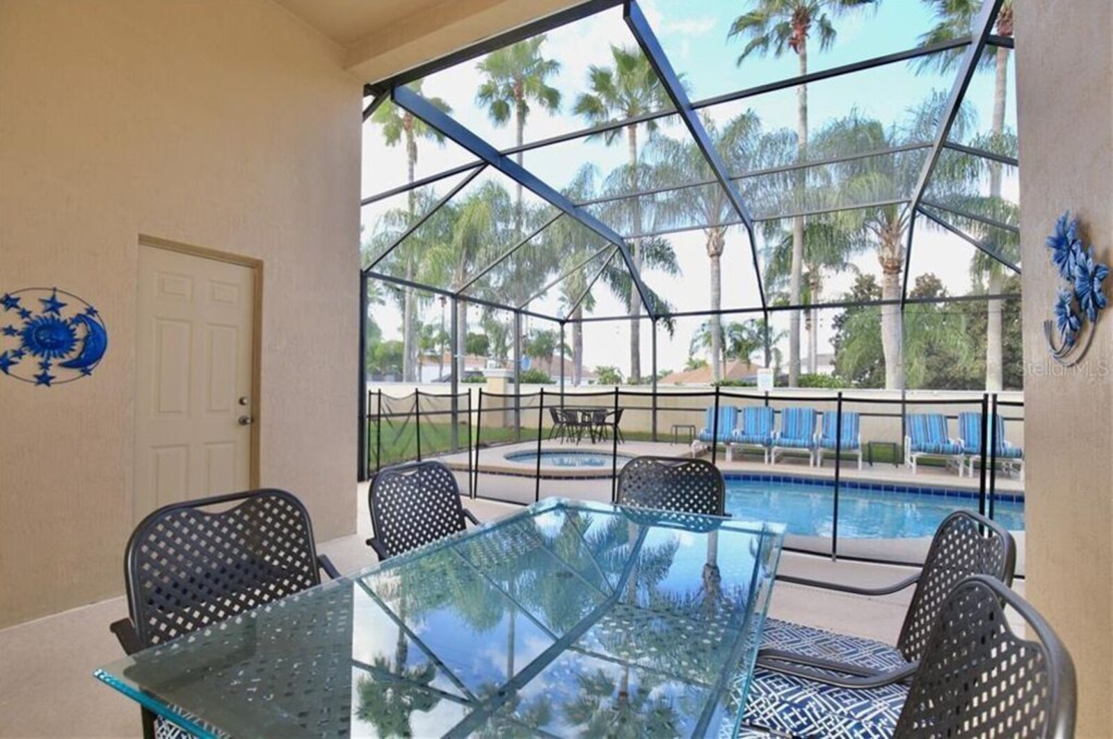 Screened private pool and spa with a shaded outdoor dining area